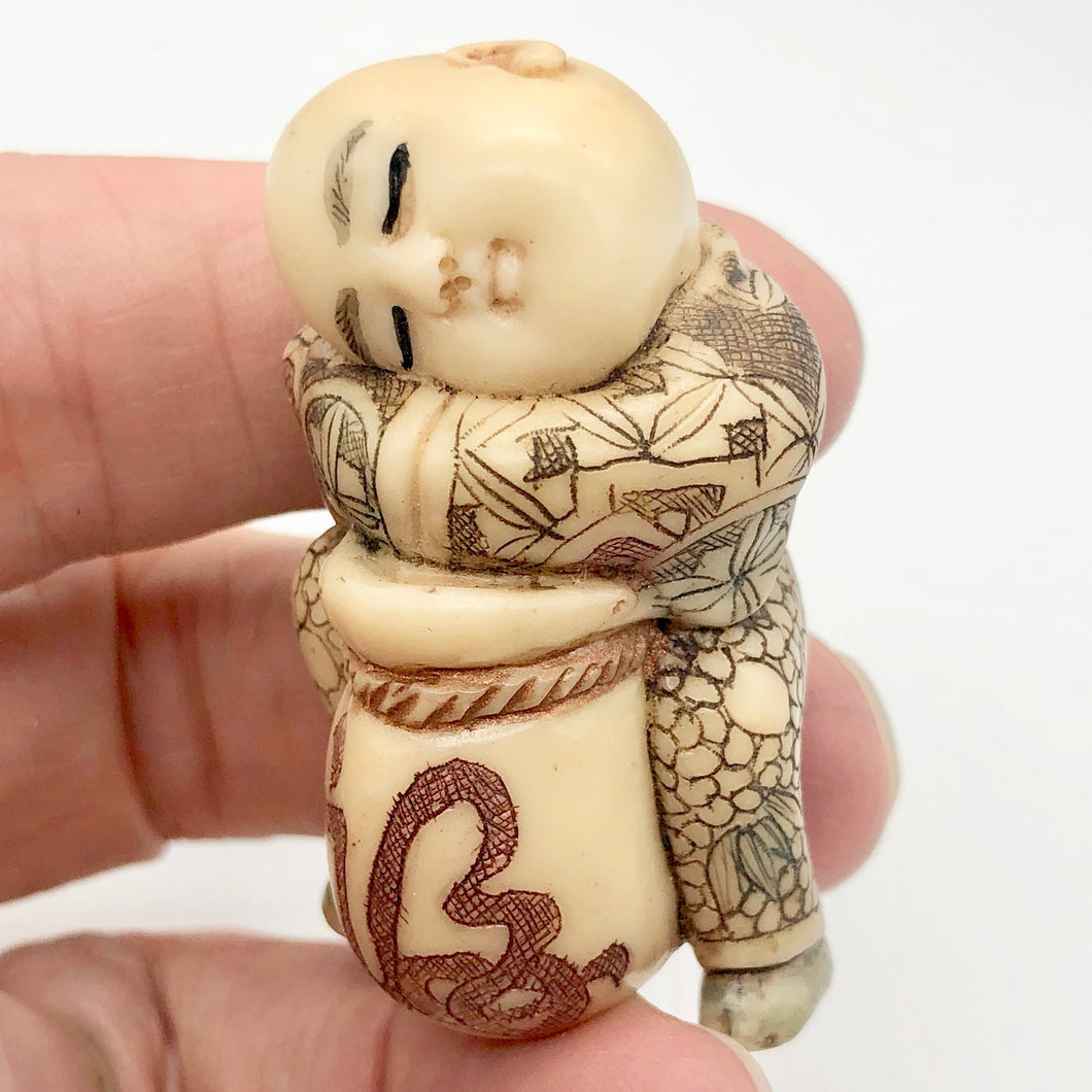 Scrimshaw carved Sleeping Asian Boy with Drum figurine - PremiumBead Primary Image 1